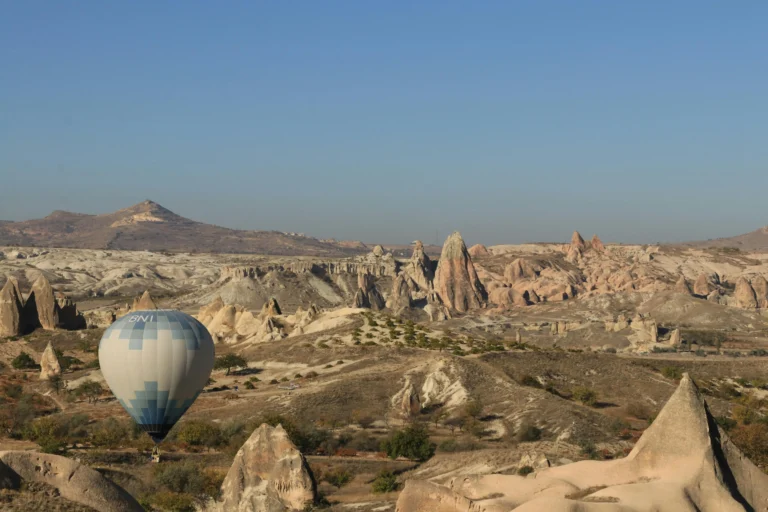 Hot air balloons flying over Cappadocia valleys at sunrise