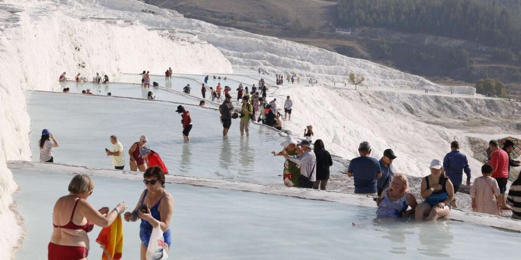 Visitors walking on Pamukkale travertines Turkey